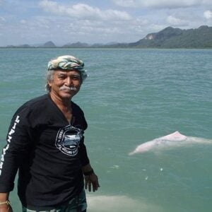 Mr Lee of Khanom Tours with a pink dolphin in the background.