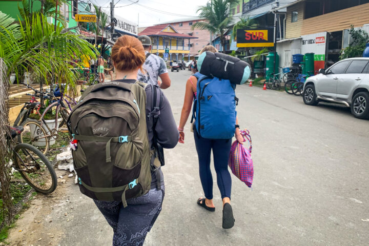 Two girls each wearing a backpack. One Osprey Farpoint, one Pacsafe Venturesafe